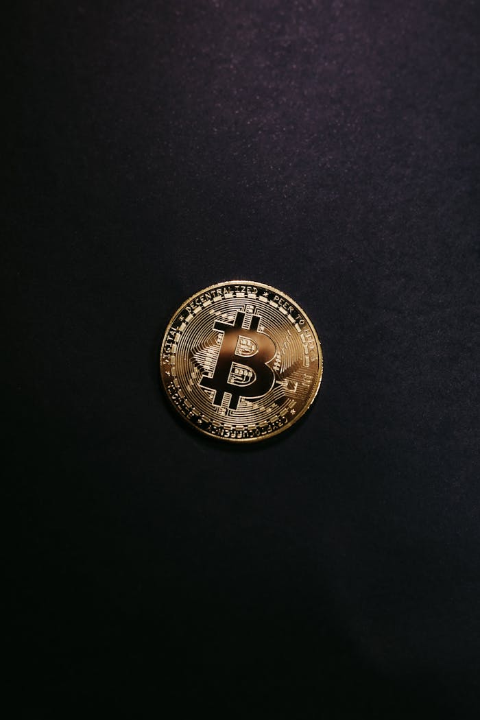 about-02 Close-up of a shiny gold bitcoin on a black background, symbolizing cryptocurrency.