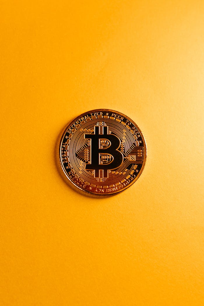 services-03 A detailed shot of a Bitcoin coin resting on a bold yellow surface, symbolizing digital currency.